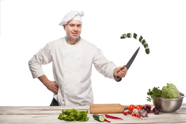 Chef cutting a green cucumber in his kitchen — Stock Photo, Image