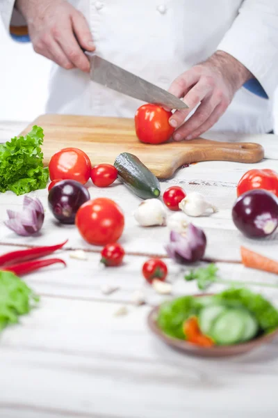 Chef tagliare un pomodoro rosso la sua cucina — Foto Stock