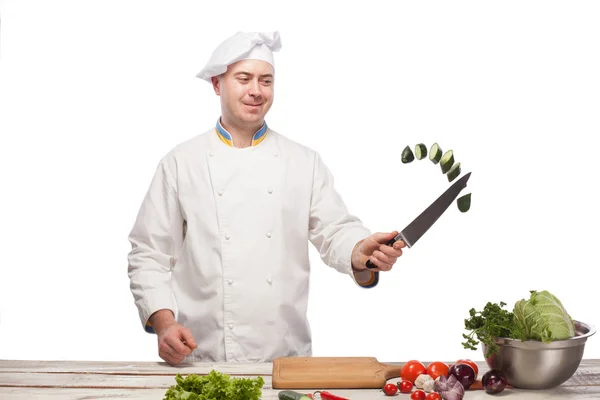 Chef snijden een groene komkommer in zijn keuken — Stockfoto