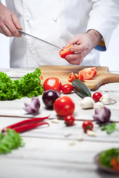 Chef tagliare un pomodoro rosso la sua cucina — Foto Stock