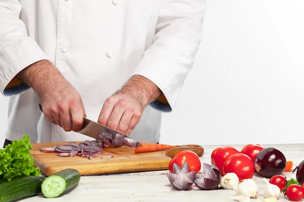 Chef tagliare una cipolla sulla sua cucina — Foto Stock
