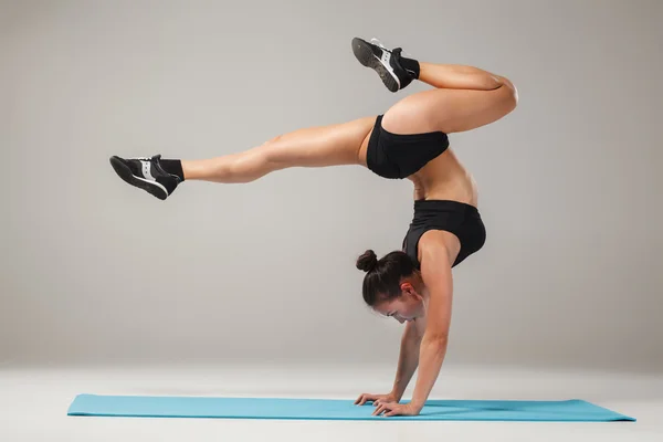 Hermosa chica deportiva de pie en pose acróbata o yoga asana — Foto de Stock