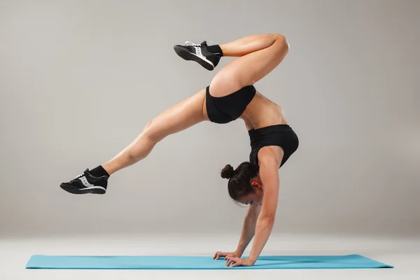 Hermosa chica deportiva de pie en pose acróbata o yoga asana —  Fotos de Stock