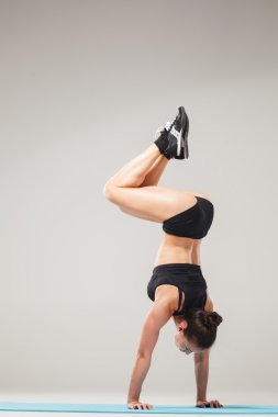 Güzel sportif kız Acrobat poz ya da yoga asana ayakta