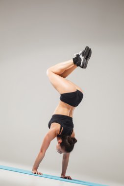 Güzel sportif kız Acrobat poz ya da yoga asana ayakta