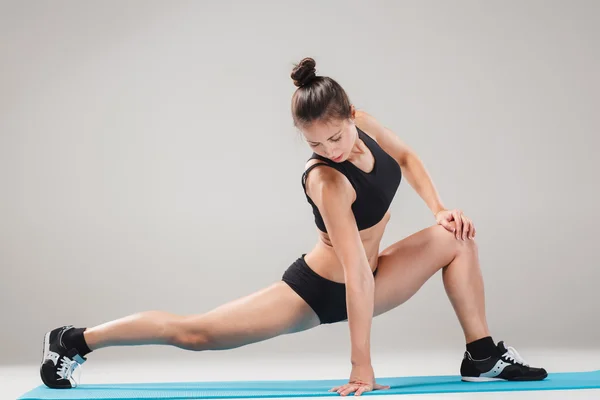 Menina desportiva bonita de pé em acrobat pose ou ioga asana — Fotografia de Stock