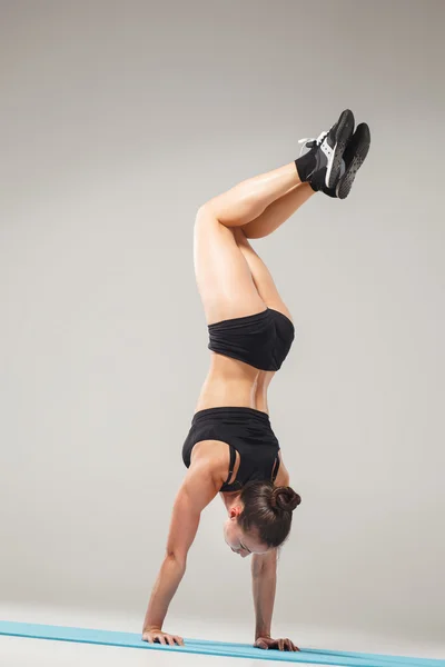 Beautiful sporty girl standing in acrobat pose or yoga asana — Stock Photo, Image