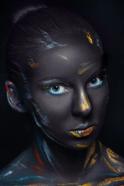 Portrait of a young woman who is posing covered with  black paint — Stock Photo, Image