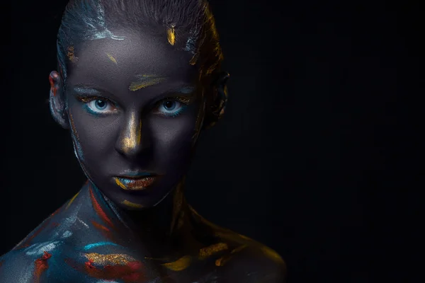 Portrait of a young woman who is posing covered with  black paint — Stock Photo, Image