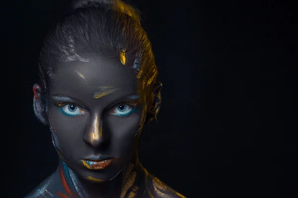 Portrait of a young woman who is posing covered with  black paint — Stock Photo, Image