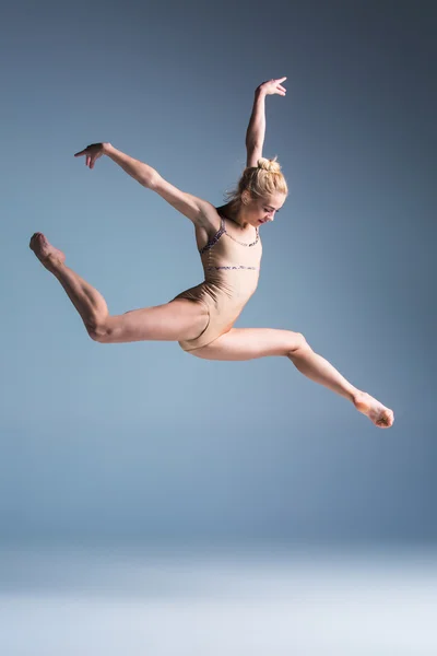 Jeune belle danseuse de style moderne sautant sur un fond de studio — Photo