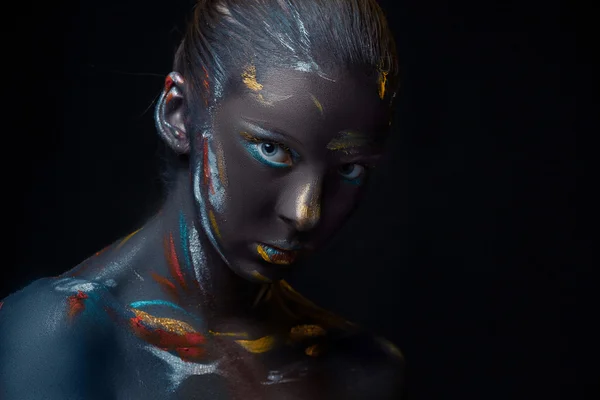 Portrait of a young woman who is posing covered with  black paint — Stock Photo, Image