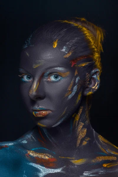 Portrait of a young woman who is posing covered with  black paint — Stock Photo, Image