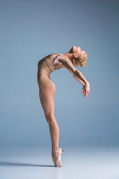 Молодая красивая танцовщица в современном стиле позирует на фоне студии — стоковое фото