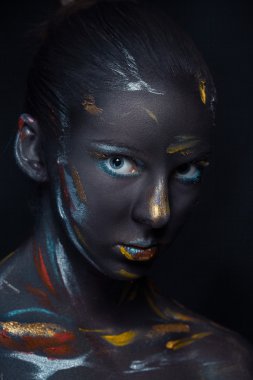 Portrait of a young woman who is posing covered with  black paint clipart