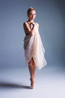 Stüdyo arka planında poz veren genç, güzel modern bir dansçı.