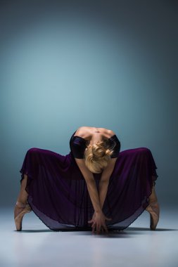 Stüdyo arka planında poz veren genç, güzel modern bir dansçı.