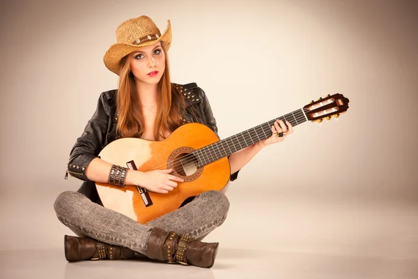 Bir kovboy şapkası ve akustik gitar güzel kız. — Stok fotoğraf