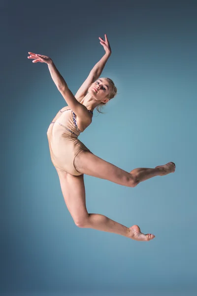 Joven hermosa bailarina de estilo moderno saltando sobre un fondo de estudio — Foto de Stock