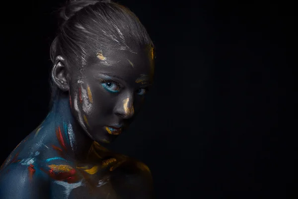 Portrait of a young woman who is posing covered with  black paint — Stock Photo, Image