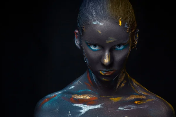 Portrait of a young woman who is posing covered with  black paint — Stock Photo, Image