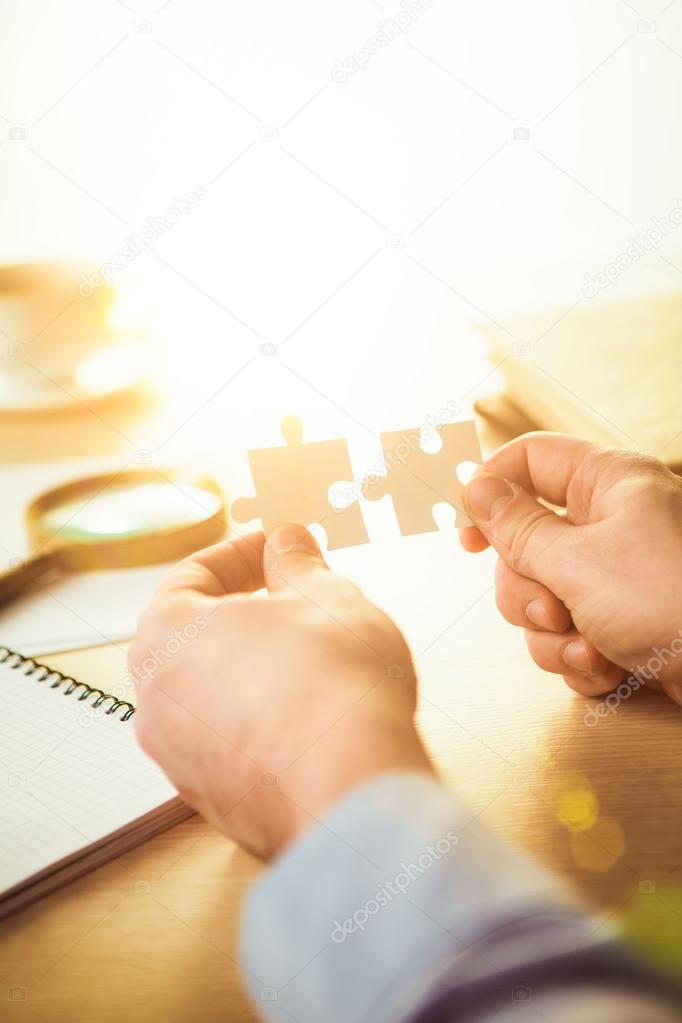 Building a business success. The hands with puzzles