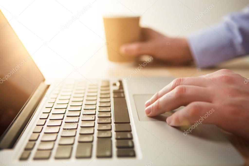 The hand on the keyboard and coffee