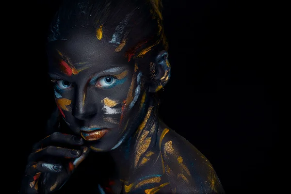 Portrait of a young woman who is posing covered with  black paint — Stock Photo, Image