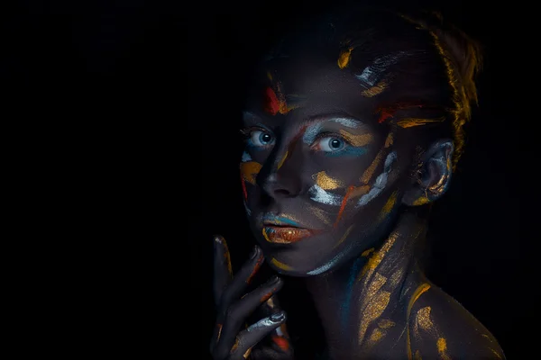 Portrait of a young woman who is posing covered with  black paint — Stock Photo, Image