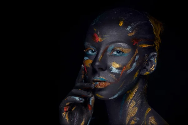 Portrait of a young woman who is posing covered with  black paint — Stock Photo, Image