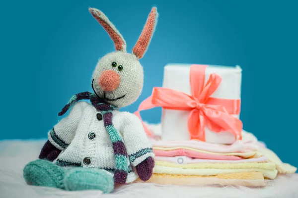 A roupa do bebê com uma caixa de presente branca — Fotografia de Stock