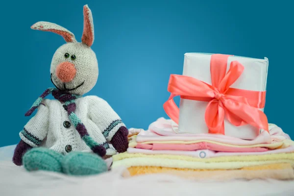 Die Babykleidung mit einer weißen Geschenkbox — Stockfoto