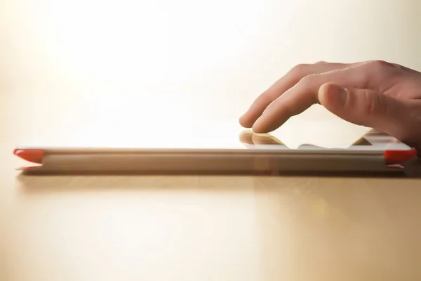 The tablet with the hand on wooden table — Stock Photo, Image