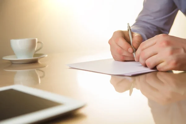 De mannelijke handen met een pen en de cup — Stockfoto