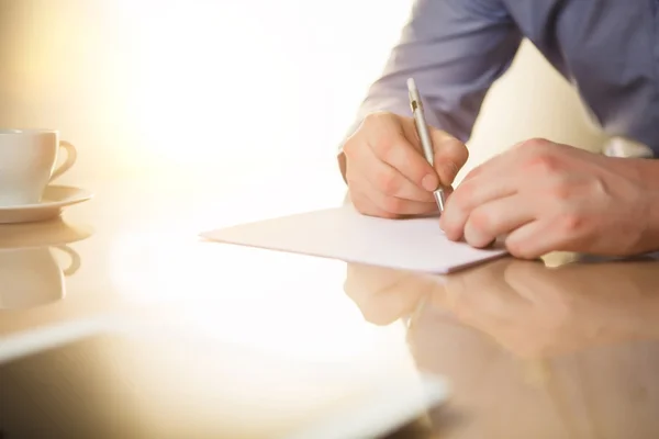 De mannelijke handen met een pen en de cup — Stockfoto