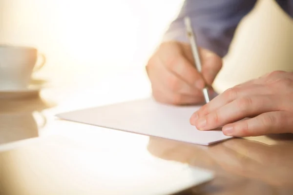 De mannelijke handen met een pen en de cup — Stockfoto