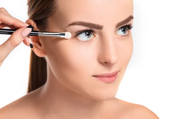 Beaux yeux féminins avec maquillage et brosse — Photo