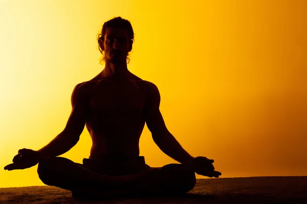 El hombre practicando yoga en la luz del atardecer — Foto de Stock