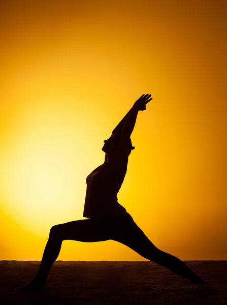 A mulher praticando ioga na luz do pôr do sol — Fotografia de Stock