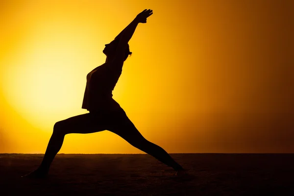 A mulher praticando ioga na luz do pôr do sol — Fotografia de Stock