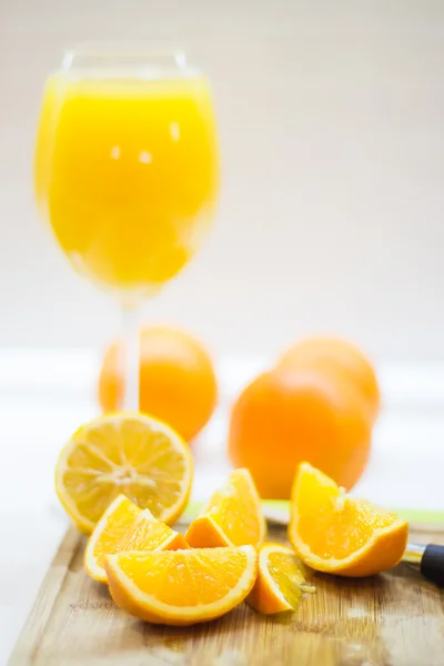 新鮮な刈り取らオレンジと木の板に汁 — ストック写真