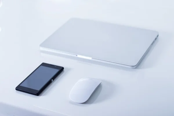 Open laptop with black smartphone — Stock Photo, Image