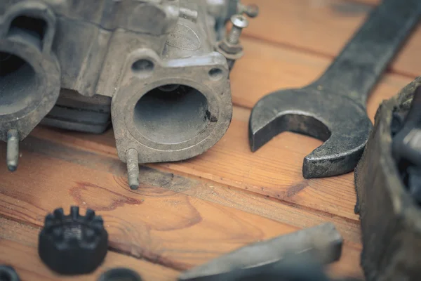 Karbüratör ahşap masa üstünde alet ile bir araba motoru için