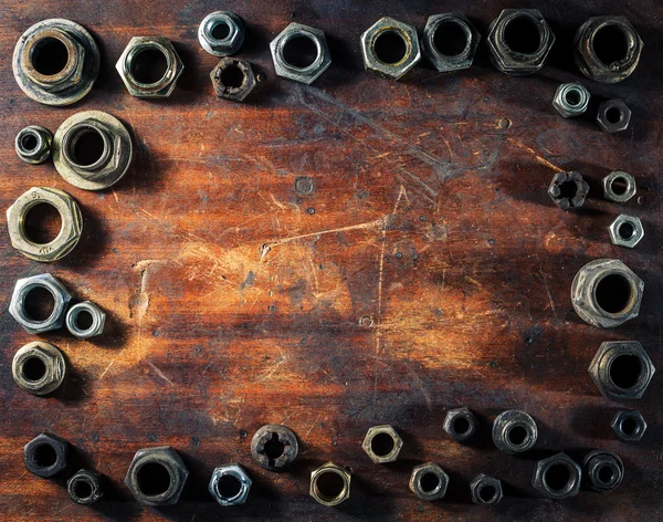 Tornillos sobre mesa de madera sucia — Foto de Stock