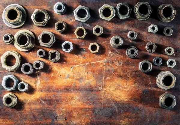 Tornillos sobre mesa de madera sucia — Foto de Stock