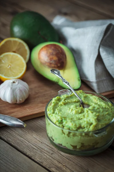 Guacamole di meja kayu dikelilingi oleh bahan — Stok Foto