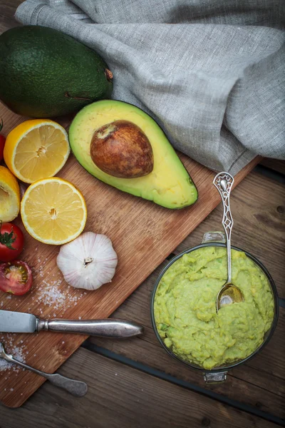 Guacamole di meja kayu dikelilingi oleh bahan — Stok Foto