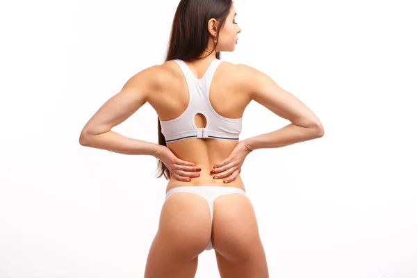 Young female touching her painful back — Stockfoto