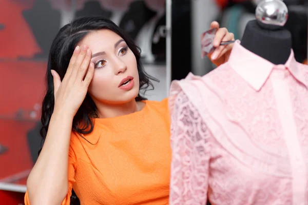 Beautiful young woman shopping in a clothing store — Stock Photo, Image