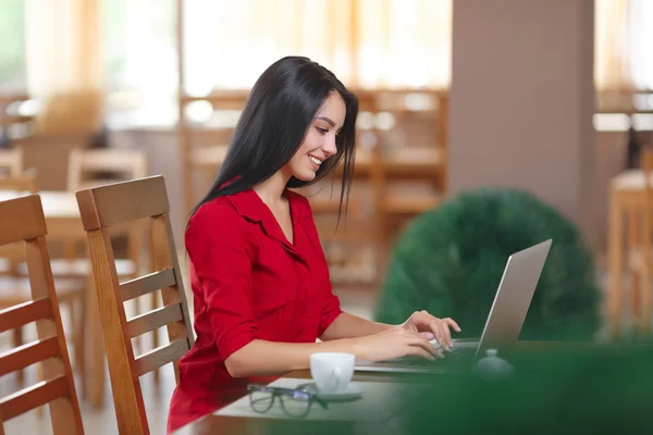 Giovane donna d'affari utilizza il computer portatile in caffè — Foto Stock